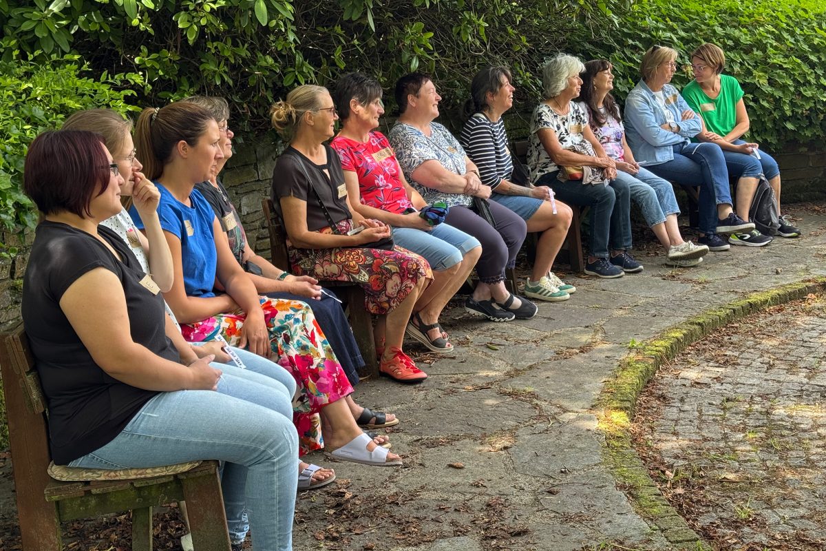 Teilnehmerinnen sitzen auf Parkbänken