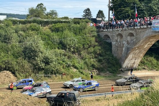 Die Autos stehen am Start, oben auf der Brücke stehen viele Zuschauer und schauen runter