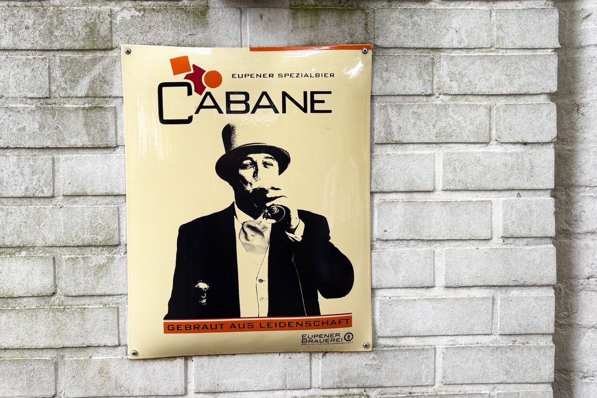 Schild "La Cabane" mit dem biertrinkenden Norbert Heukemes selbst als Motiv
