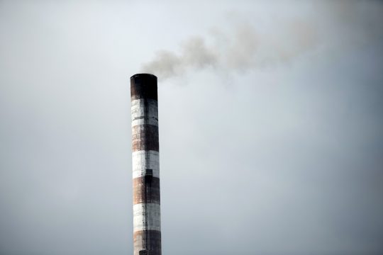Ein Fabrikschlot vor grauem Himmel