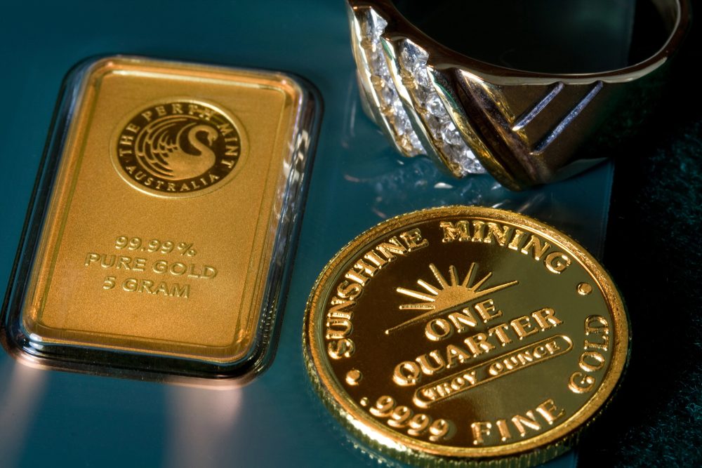 Goldbarren, Goldmünze und ein Goldring