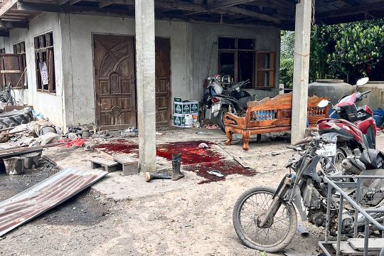 ein nach einem Raketeneinschlag zerstörtes Haus und Blutflecken auf dem Boden