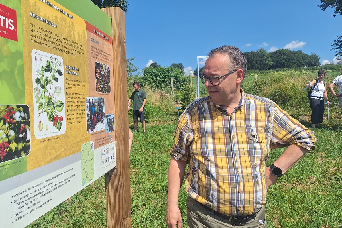Rainer Stoffels steht neben einer Informationstafel