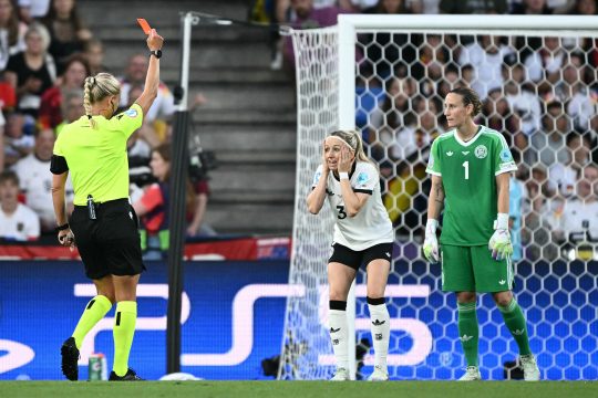 Die Schiedsrichterin hält die Rote Karte hoch, Kathy Hendrich fasst sich mit beiden Händen ins Gesicht und guckt entgeistert