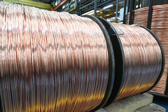 Große Spulen mit aufgewickeltem Kupferdraht in einer Industrie-Lagerhalle