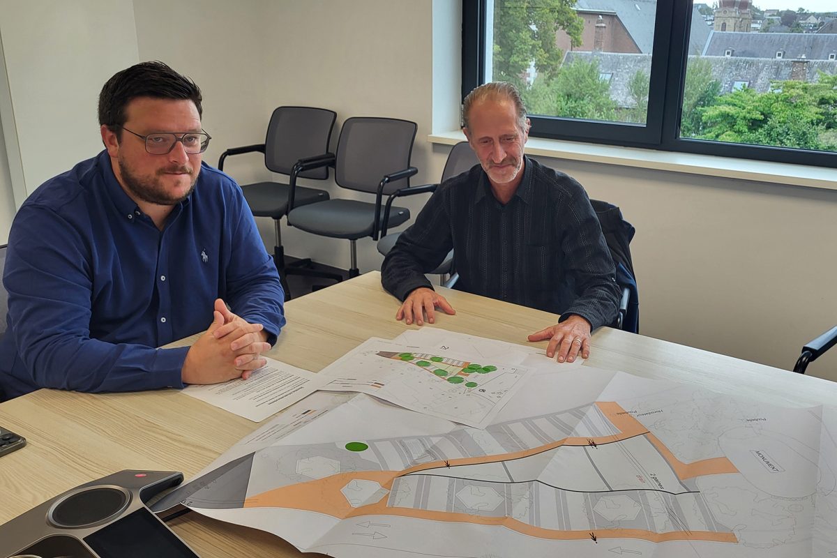 Schöffe Lucas Reul und Christoph Mertens vom technischen Dienst Eupen vor den Plänen für den Parkplatz oberhalb des Denkmals am Werthplatz