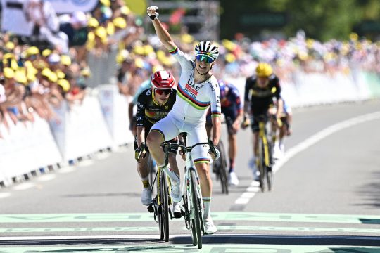 Der Slowene Tadej Pogacar jubelt, als er über die Ziellinie fährt