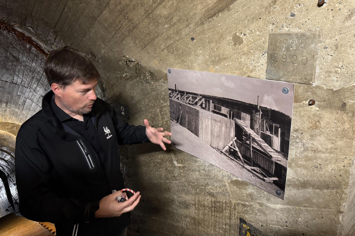 Bezirksleiter Vincent Lognay im Inneren der Staumauer vor einem historischen Bild