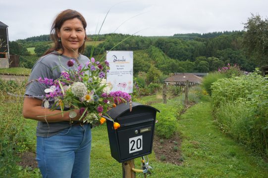 Sylvia George mit einem Blumenstrauß