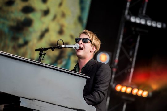 Tom Odell sitzt auf der Bühne am Flügel und singt