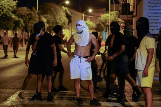 Mehrere Vermummte stehen zusammen auf der Straße