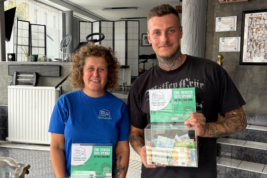 Vertreter vom Tierheim und vom Tattoostudio mit dem gesammelten Geld