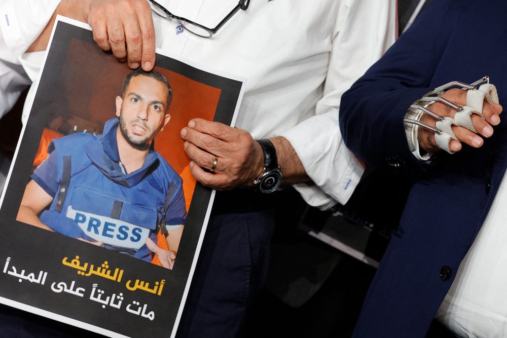 zwei Mitarbeiter von Al-Dschasira mit einem Foto des getöteten Journalisten Anas al-Scharif