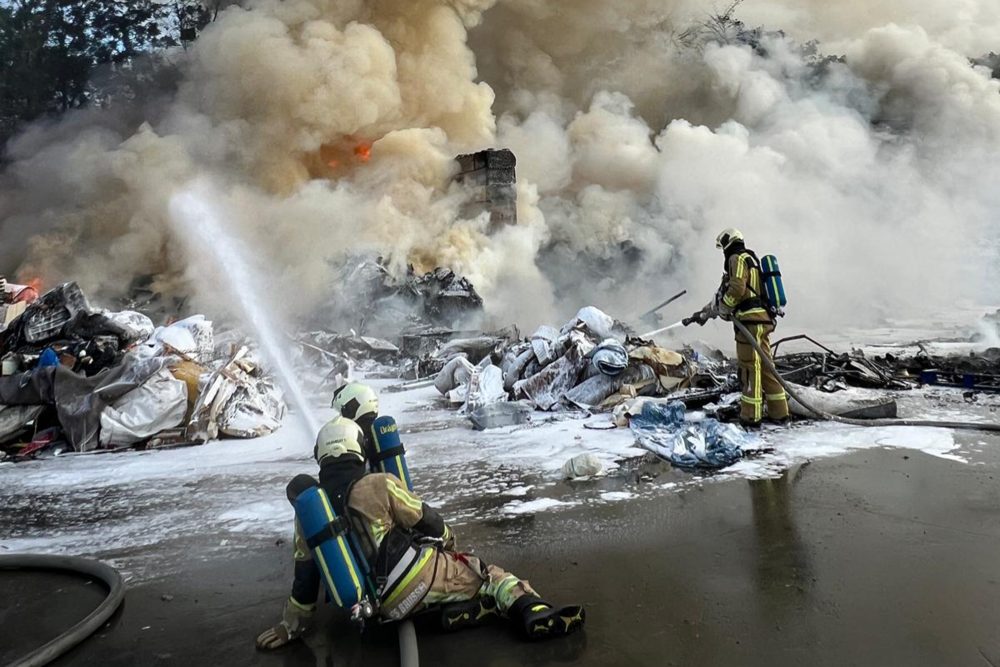 Feuerwehrleute beim Löscheinsatz, es gibt eine dichte Qualmwolke