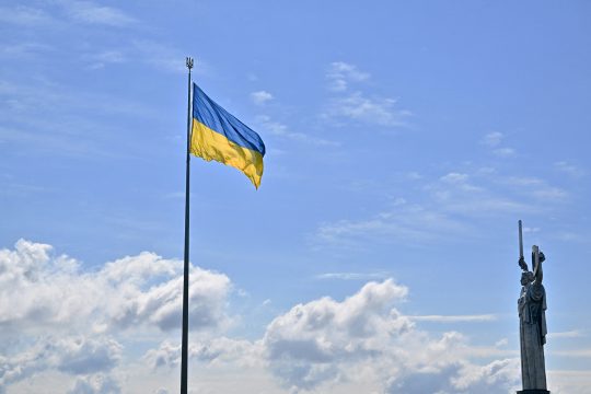 Die ukrainische Flagge weht vor der Mutter-Heimat-Statue in Kiew