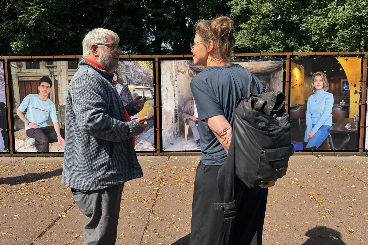 Künstler Willi Filz im Gespräch mit einer Frau vor der Fotoinstallation