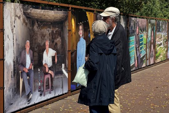 Zwei Menschen schauen sich die Porträtfotos an