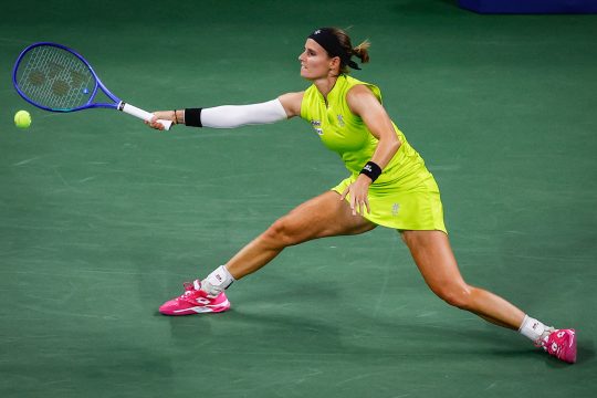 Greet Minnen schlägt den Ball zurück