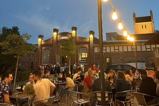 Terrasse am Alten Schlachthof in Eupen mit Menschen, die an Tischen sitzen