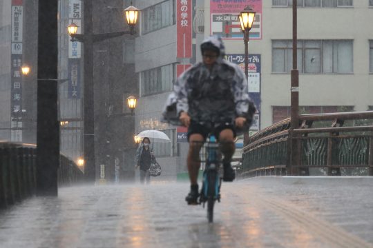 Fahrradfahrer und Fußgänger im heftigen Regen
