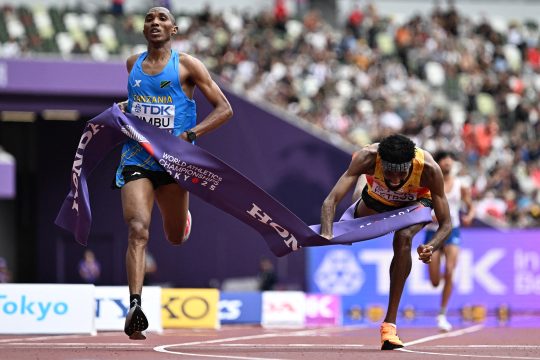 Alphonce Felix Simbu aus Tansania überquert die Ziellinie, der Zweitplatzierte Amanal Petros ist kurz dahinter und fällt zu Boden