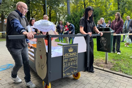 Bettenrennen-Teilnehmer in einem Bett des Kartoffellieferanten Bonni