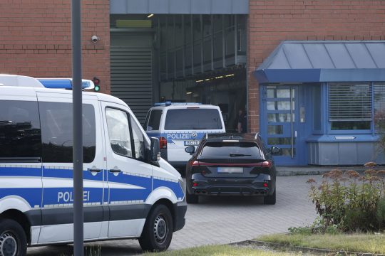 Polizeiautos und das Auto des Anwalts des Verdächtigen vor der Justizvollzugsanstalt Sehnde