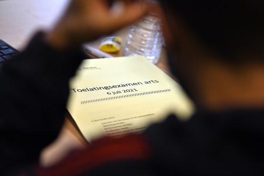 Person sitzt vor einem Tisch beim Zulassungstest zum Medizinstudium in Flandern