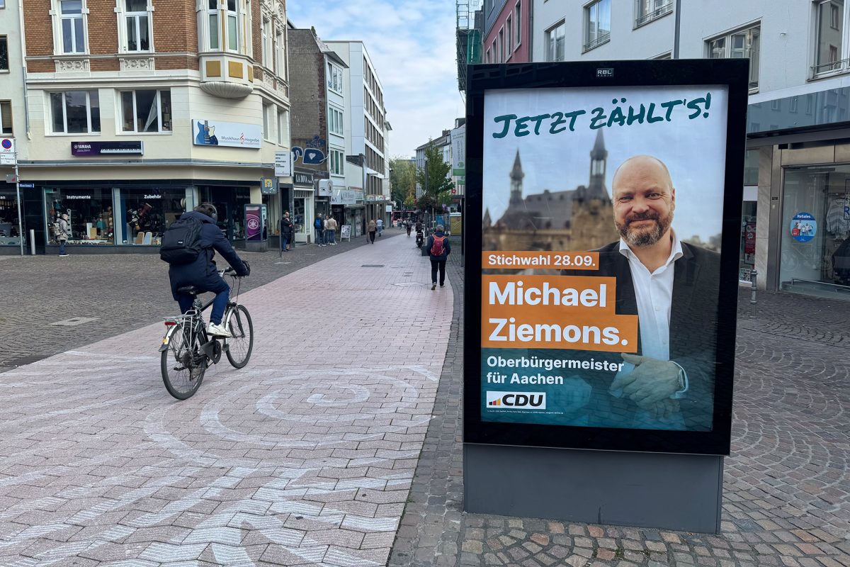 Wahlplakat mit Porträt des gewählten Bürgermeisterkandidaten Michael Ziemons in einer Fußgängerzone