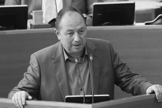 Schwarz-Weiß-Bild von Pascal Baurain am Rednerpult im Wallonischen Parlament