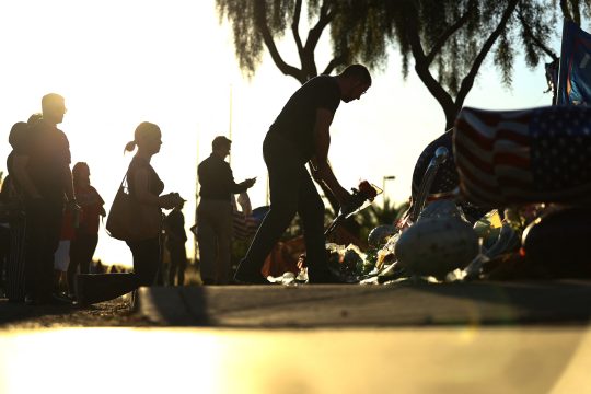 Menschen legen vor dem Hauptsitz der Organisation "Turning Point" Blumen nieder