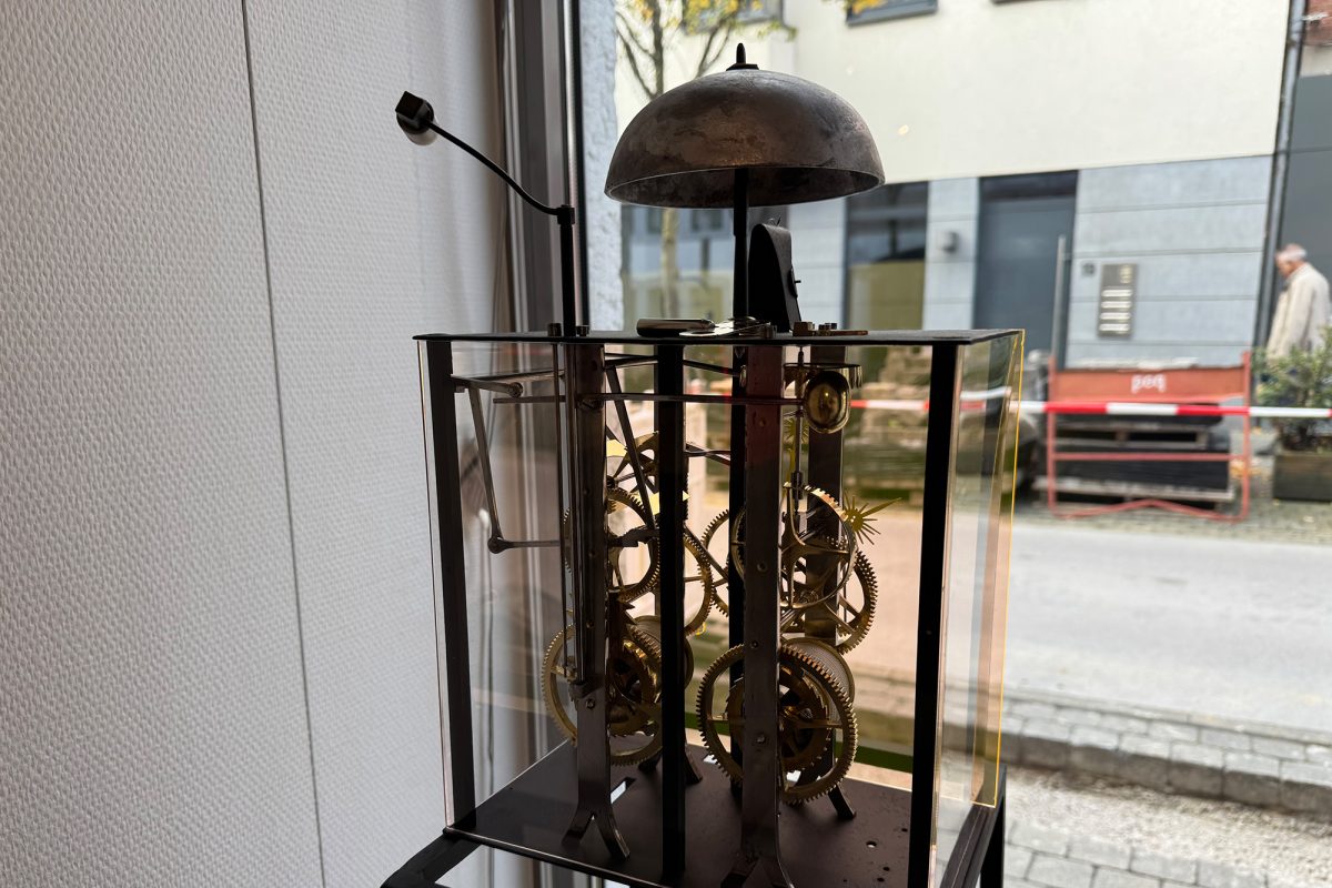 Besondere Uhr mit großem Uhrwerk in einem Glaskasten