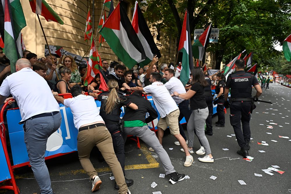 Mitglieder des Vuelta-Organisationsteams und Polizisten versuchen, die Demonstranten von der Strecke fernzuhalten