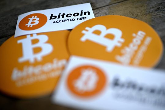 "Hier wird der Bitcoin angenommen" auf Abziehbildern in einer Bar
