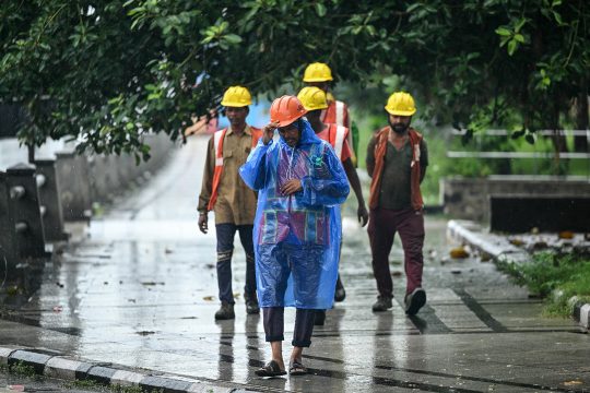 Metro-Arbeiter in Arbeitskleidung und mit Helmen auf der Straße