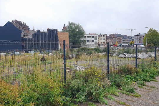 Brach liegendes Gelände hinter einem Zaun