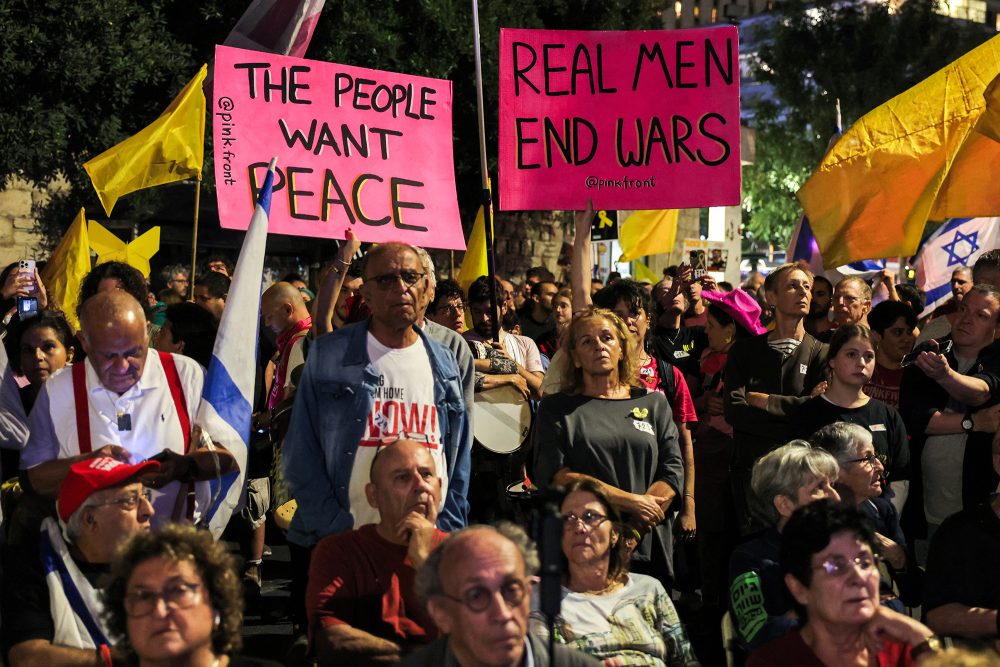 "Die Menschen wollen Frieden" und "Echte Männer beenden Kriege" auf Plakaten bei einer Demonstration vor dem Haus des israelischen Premiers Netanjahu am Samstag