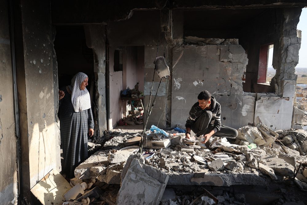Eine Frau und ihr Enkel durchsuchen ihr zerstörtes Haus im Gazastreifen
