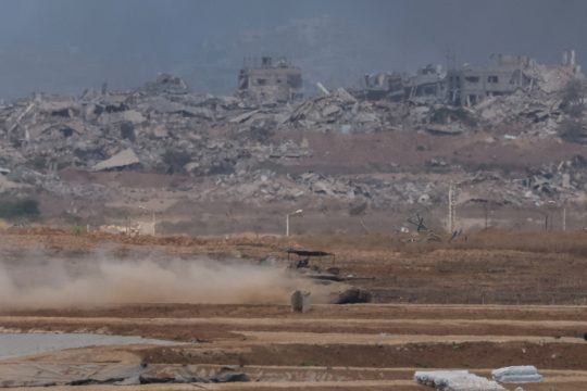 Israelischer Panzer fährt an zerstörten Gebäuden in Gaza vorbei