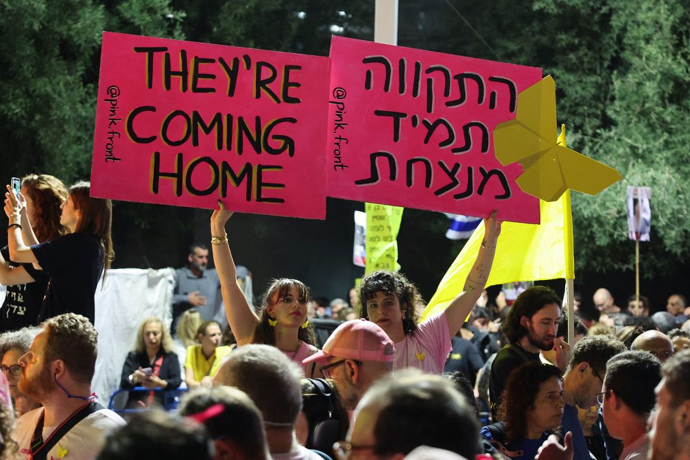 Israelis halten Plakate hoch zur Rückkehr der Geiseln