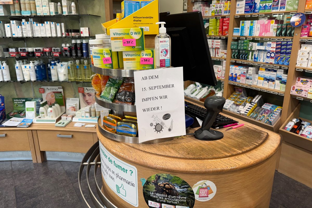 Auf dem Kassentresen steht ein Schild, auf dem steht: "Ab dem 15. September impfen wir wieder"