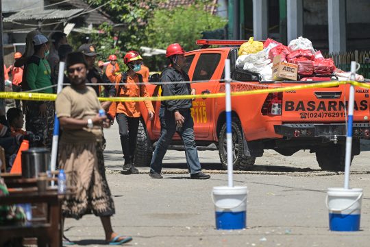 Rettungskräfte vor der abgesperrten Zone bei der eingestürzten Schule