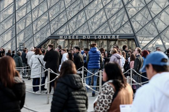 Besucher warten vor dem Eingang des Louvre in Paris