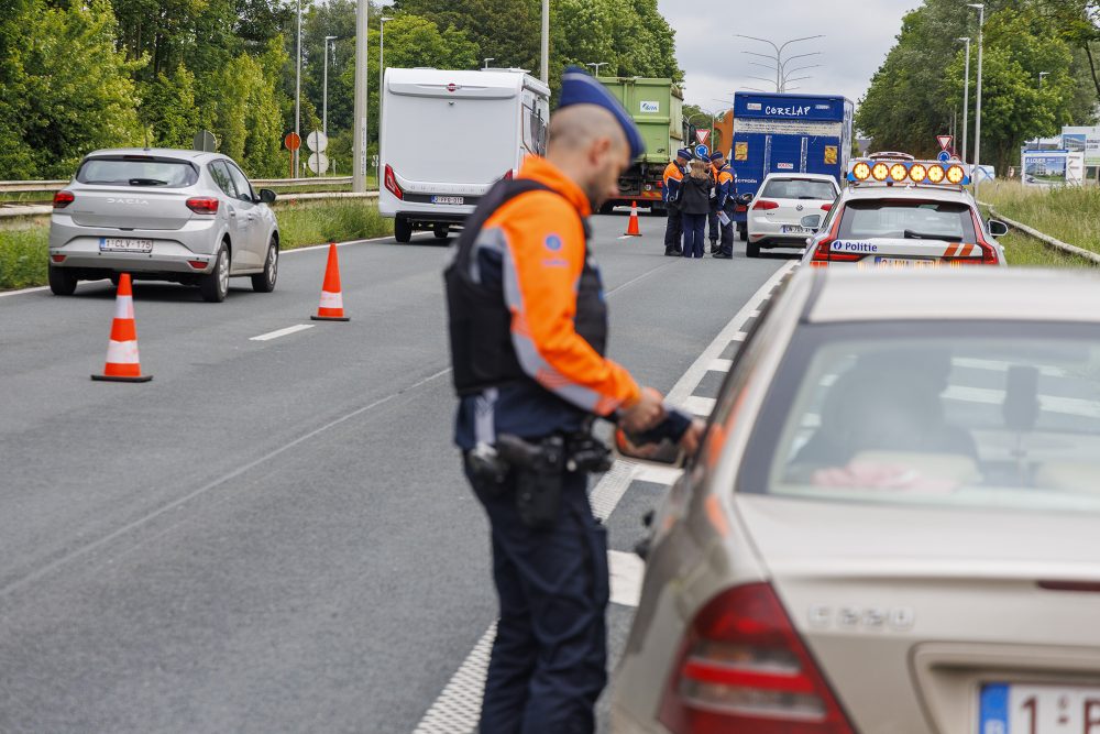 Ein Polizist kontrolliert einen Autofahrer an der Autobahn