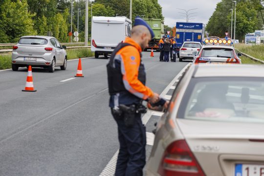 Ein Polizist kontrolliert einen Autofahrer an der Autobahn