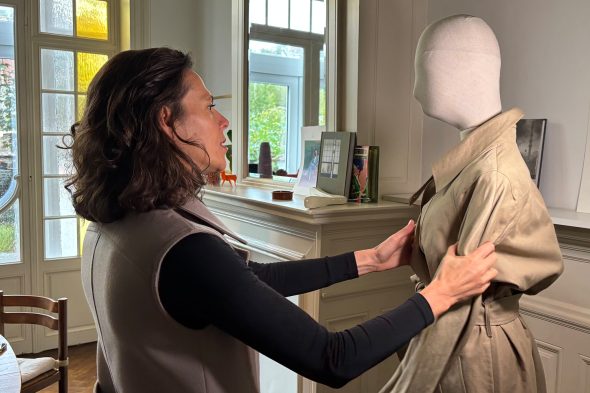 Ramona Wilmes mit einem Trenchcoat-Modell, das für eine Kundin personalisiert werden soll