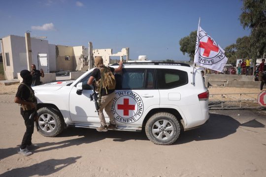 Fahrzeug des Roten Kreuzes und vermummte Hamas-Kämpfer