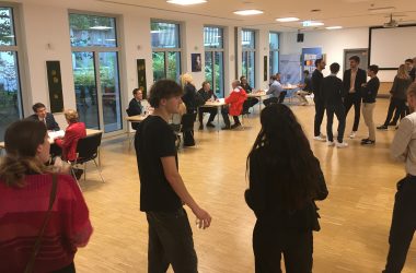 Teilnehmer stehen im im Saal