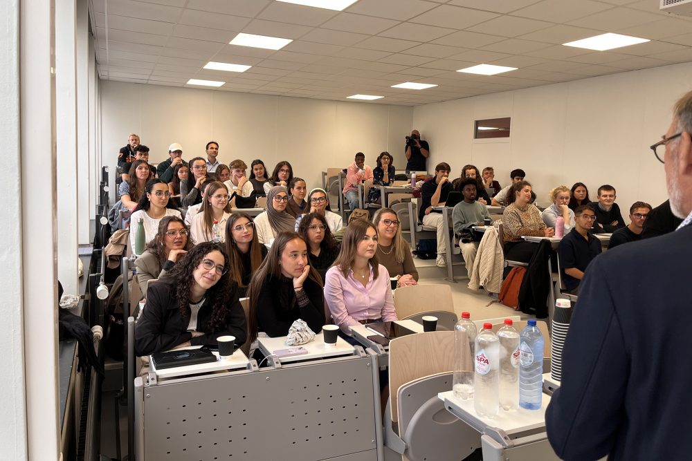 Studenten an der Universität von Mons sitzen in einem Seminarraum und hören dem Professor zu