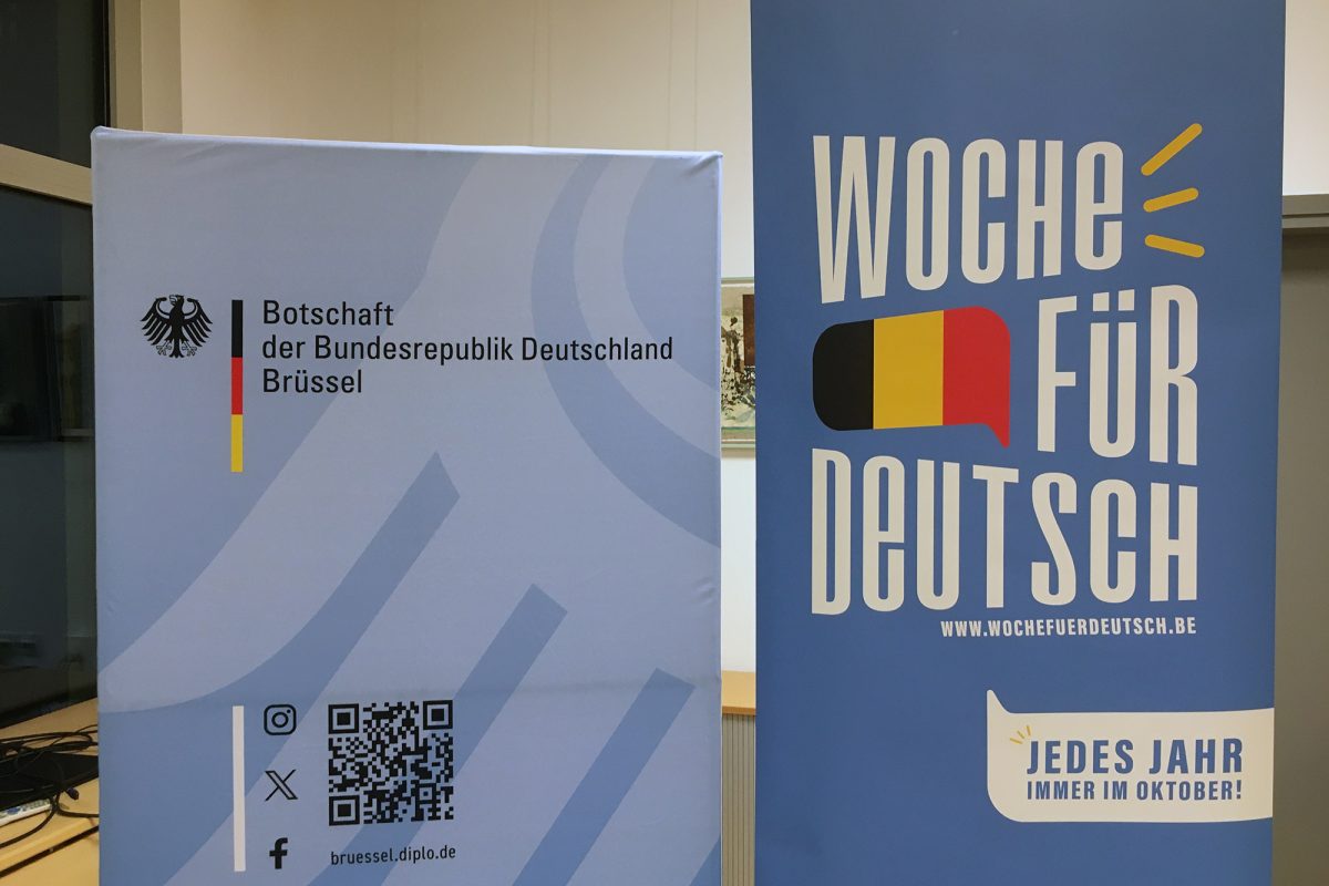 Plakat der Woche für Deutsch neben einer Stellwand der Deutschen Botschaft Brüssel